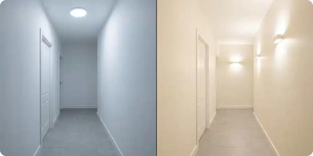 Comparaison du même couloir sans fenêtre peint en blanc pur sous néon froid (rendu grisâtre) et en blanc cassé sous appliques à 3 000 K (rendu lumineux)