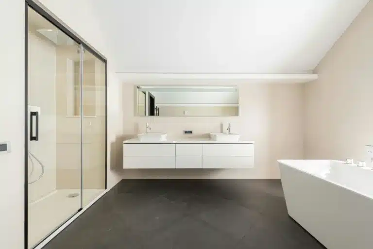 Salle de bain moderne avec douche à l'italienne de plain-pied, le caniveau assure l'évacuation au niveau du sol
